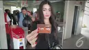 Seorang penumpang cantik memperlihatkan e-ticket yang baru saja dibelinya di halte busway Blok M, Jakarta, Senin (11/8/2014)(Liputan6.com/Faizal Fanani)