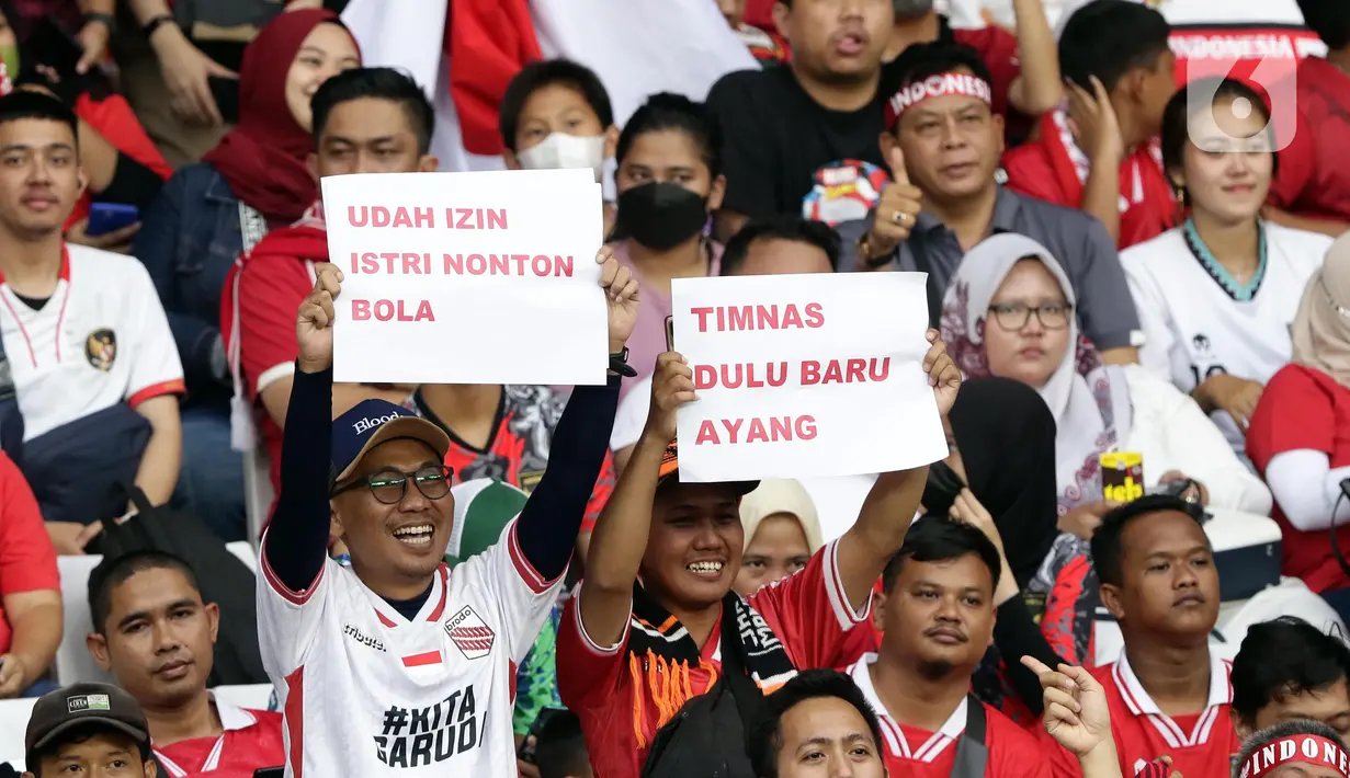 Pendukung timnas Indonesia membentang kertas tulisan saat menyaksikan laga kualifikasi Grup A Piala AFF 2022 antara Indonesia melawan Kamboja di di Stadion Utama Gelora Bung Karno, Jakarta, Jumat (23/12/2022). Indonesia unggul 2-1 atas Kamboja lewat gol yang dicetak Egy Maulana Vikry dan Witan Sulaeman. (Liputan6.com/Helmi Fithriansyah)