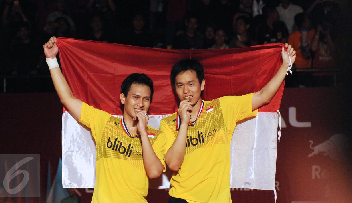 Ganda putra Indonesia, M Ahsan/Hendra Setiawan menggigit medali usai menumbangkan Liu Xiaolong/QiuZihan (Tiongkok) di final Total BWF World Championships 2015, Jakarta, Minggu (16/8/2015). Ahsan/Hendra unggul 21-17, 21-14.(Liputan6.com/Helmi Fithriansyah)