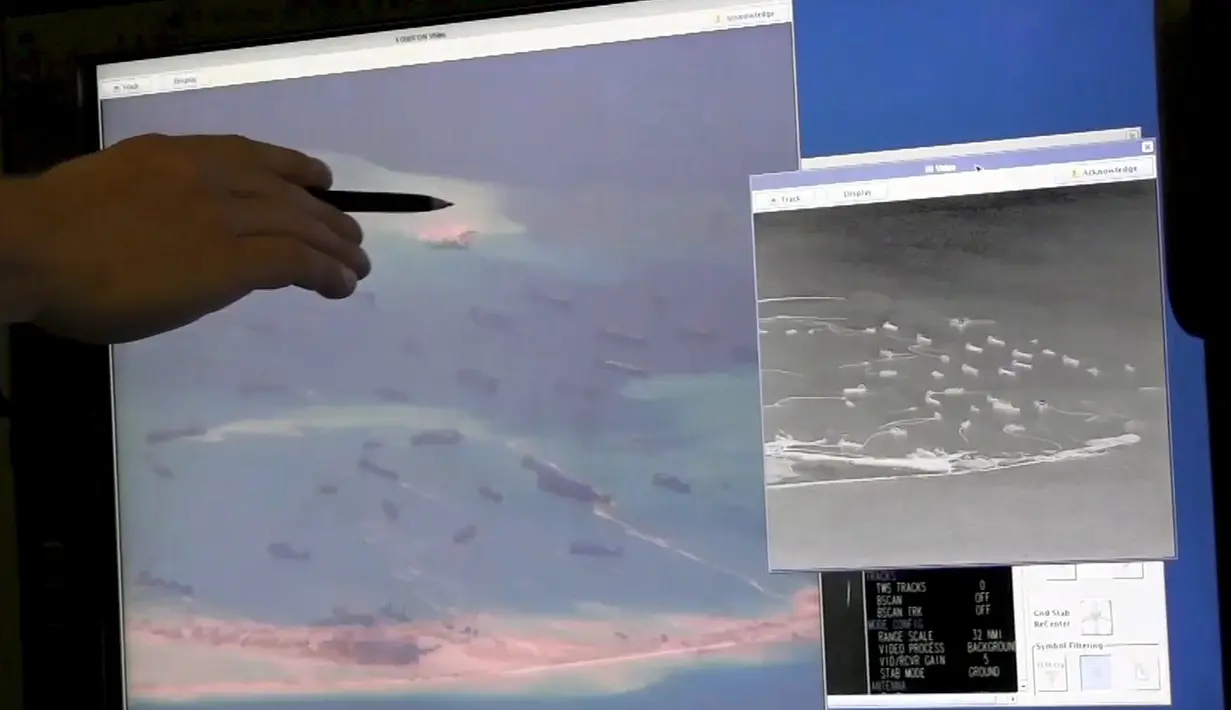Seorang anggota Angkatan Laut AS memberitahukan kontruksi yang dilakukan Cina untuk mereklamasi terumbu karang Fiery Cross Reef di laut Cina selatan, (21/5/2015). Kabarnya Pesawat Militer Cina telah mendarat pertama di pulau itu. (REUTERS / A.S . Navy)