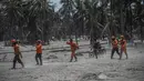 Tim penyelamat tiba untuk mencari korban di rumah yang terkubur abu vulkanik letusan Gunung Semeru di Desa Sumber Wuluh, Lumajang, Jawa Timur, Selasa (7/12/2021). Letusan Gunung Semeru menewaskan sedikitnya 34 orang. (AFP/Juni Kriswanto)