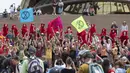 Aktivis yang terbagung dalam kelompok Red Rebels berunjuk rasa dalam demonstrasi protes iklim di Sydney (15/12/2019). Pengunjuk rasa melakukan aksi di depan landmark Gedung Opera Sydney menuntut pemerintah Australia menanggulangi asap yang menyebabkan masalah kesehatan. (AFP/Wendell Teodoro)