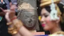 Penari menari di depan kepala patung dewa Hindu dari abad ke-7 pada upacara di Museum Nasional Kamboja, Kamis (21/1). Prancis mengembalikan kepala patung dewa yang disebut Harihara itu setelah diambil lebih dari 130 tahun lalu. (REUTERS/Samrang Pring)