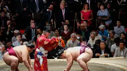 Presiden AS Donald Trump (dua kiri) berbincang dengan PM Jepang Shinzo Abe (kiri) saat menyaksikan Tokyo Grand Sumo Tournament di Stadion Ryogoku Kokugikan, Tokyo, Jepang, Minggu (26/5/2019). Nonton bareng ini dilakukan di sela-sela kunjungan kenegaraan Trump ke Jepang. (AP Photo/Evan Vucci)