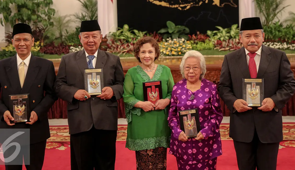 Ahli waris menunjukkan piagam gelar pahlawan nasional yang diberikan langsung oleh Presiden Jokowi di Istana Negara, Jakarta, Kamis (5/11). Penganugerahan ini merupakan agenda rutin jelang Hari Pahlawan tiap 10 November. (Liputan6.com/Faizal Fanani)