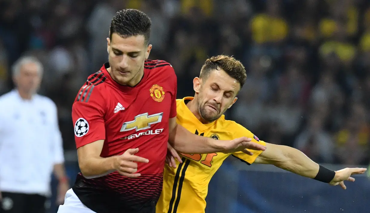 Diogo Dalot menggiring bola dari kawalan pemain Young Boys, Miralem Sulejmani selama pertandingan grup H Liga Champions di The Stade de Suisse (19/9). Dalot dipercaya Jose Mourinho untuk mengantikan Antonio Valencia. (AFP Photo/Alain Grosclaude)