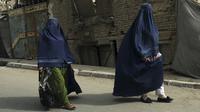 Perempuan Afghanistan dengan burqa berjalan di sebuah jalan di Kabul, pada Minggu (22/8/2021). Taliban merebut kembali kendali Afghanistan, hampir dua dekade setelah mereka digulingkan koalisi pimpinan AS. (AP Photo/ Rahmat Gul)