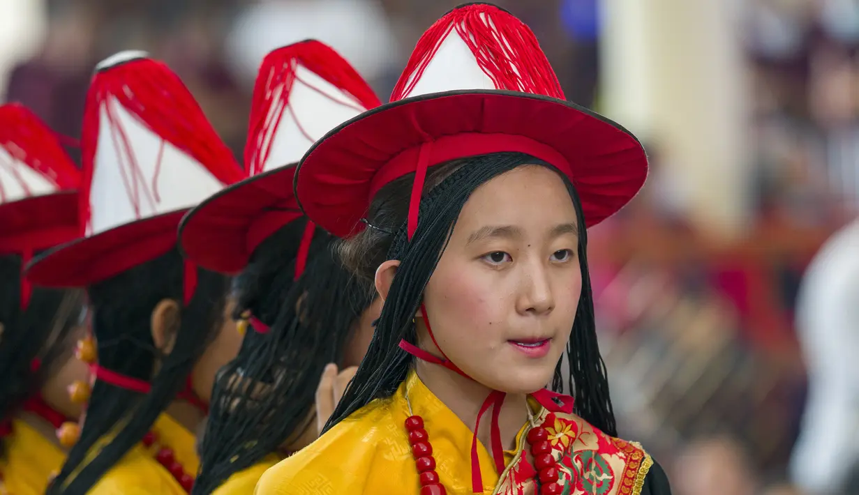 <p>Para seniman memainkan lagu-lagu selamat tradisional ketika pemimpin spiritual Tibet ini tiba dengan van terbuka untuk memimpin perayaan di halaman Kuil Tsuglakhang, yang dihias dengan bendera Tibet dan Buddha serta potret-potret. (AP Photo/Ashwini Bhatia)</p>