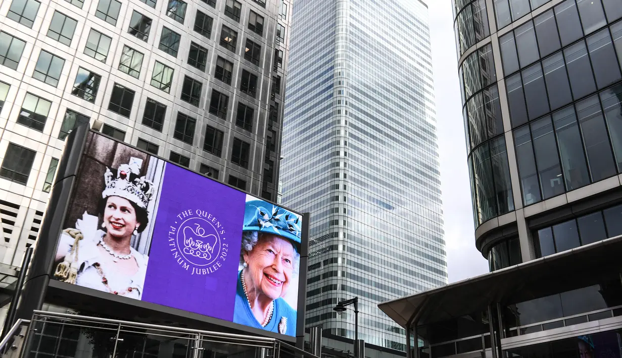 Gambar Ratu Elizabeth II dari Inggris ditampilkan pada layar digital untuk menandai dimulainya di distrik Canary Wharf, London, pada 6 Februari 2022. Ratu Elizabeth II menjadi raja Inggris pertama yang memerintah selama tujuh dekade. (Daniel LEAL/AFP)