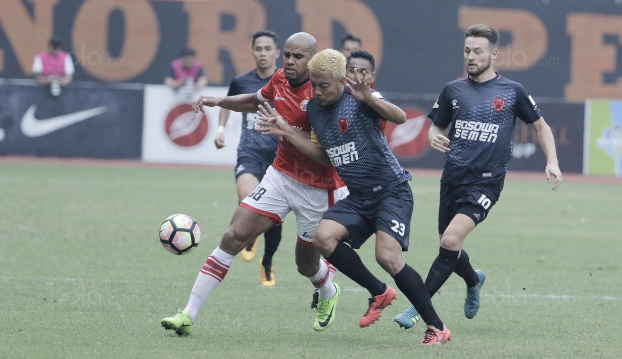 Striker Persija, Reinaldo, berebut bola dengan kapten PSM, Hamkah Hamzah pada laga Liga 1 di Stadion Patriot, Bekasi, Selasa  (15/8/2017). Persija bermain imbang 2-2 dengan PSM. (Bola.com/M Iqbal Ichsan)