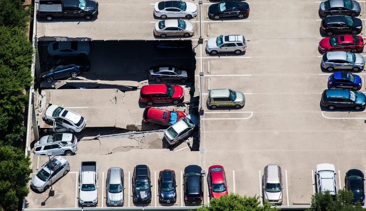 Kondisi sebuah tempat parkir dua lantai yang runtuh di Irving, Texas, Selasa (31/7). Tim penyelamat dan K-9 memastikan tidak ada orang yang berada dalam mobil saat kejadian berlangsung. (Ashley Landis/The Dallas Morning News via AP)
