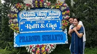 Raffi Ahmad dan Nagita Slavina berpose mesra di samping bunga papan kiriman Prabowo Subianto. (dok. Instagram @raffinagita1717/https://www.instagram.com/p/C3eUoocPMGY/Dinny Mutiah)