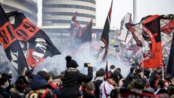 Para pendukung AC Milan mengibarkan bendera dan menyalakan flare di luar Stadion San Siro sebelum dimulainya laga lanjutan Liga Italia 2020/21 antara AC Milan melawan Inter Milan, Minggu (21/2/2021). AC Milan kalah 0-3 dari Inter Milan. (LaPresse via AP/Claudio Furlan)