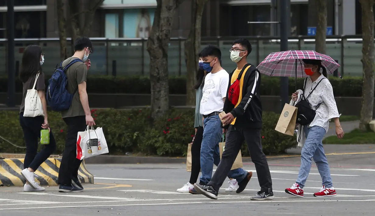Warga memakai masker untuk melindungi diri dari penyebaran COVID-19 di Taipei, Taiwan, Sabtu (15/5/2021). Taiwan yang telah berhasil membuat iri dalam menahan COVID-19 memberlakukan pembatasan baru di ibu kotanya saat memerangi wabah terburuk sejak pandemi dimulai. (AP Photo/Chiang Ying-ying)