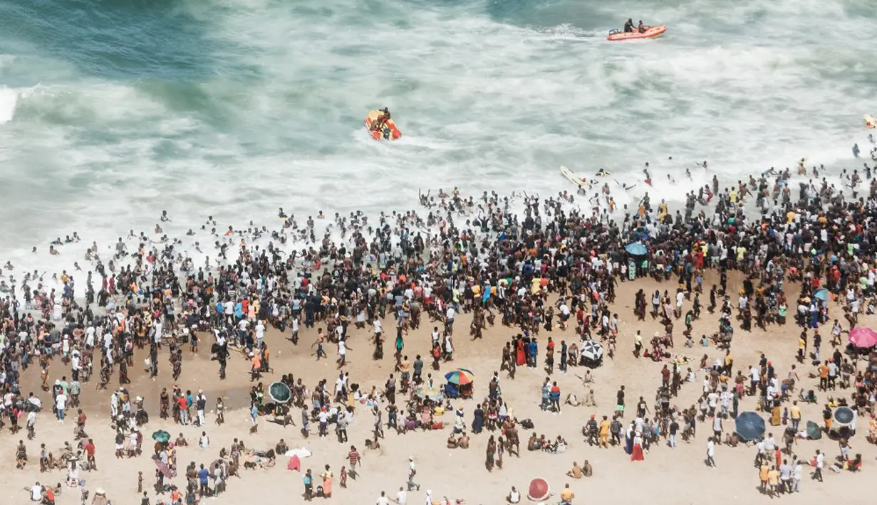 Ribuan wisatawan bersuka ria saat perayaan Tahun Baru di North Pier Beach, Durban, Afrika Selatan, 1 Januari 2022. Menurut polisi Afrika Selatan, hampir 50 ribu orang diperkirakan akan menghabiskan hari di pantai. (Rajesh JANTILAL/AFP)