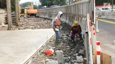 Pekerja menyelesaikan proyek revitalisasi trotoar di kawasan Bundaran Hotel Indonesia, Jakarta, Selasa (24/9/2019). Pemerintah Provinsi (Pemprov) DKI tengah mengebut pembangunan revitalisasi trotoar di sejumlah titik Ibu Kota yang ditargetkan rampung akhir 2019 mendatang. (Liputan6.com/Angga Yuniar)