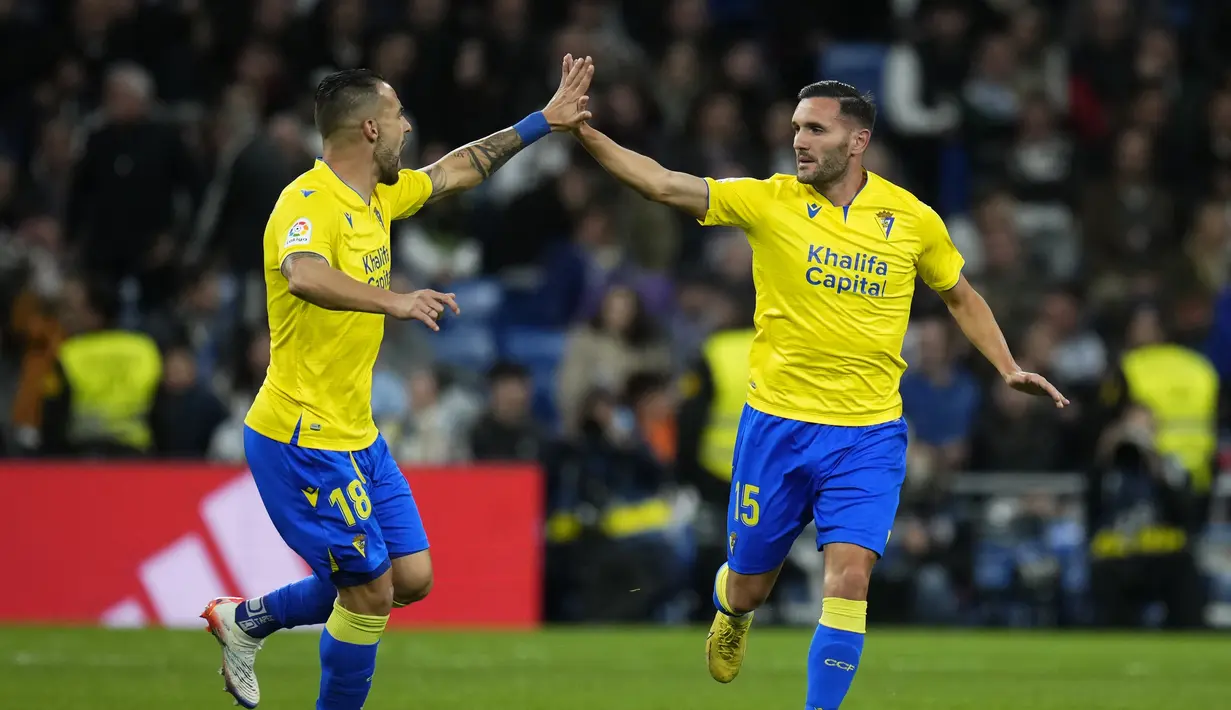 Pemain Cadiz, Lucas Perez (kanan) berselebrasi dengan rekan setimnya Alvaro Negredo setelah mencetak gol ke gawang Real Madrid pada pertandingan lanjutan La Liga Spanyol di stadion Santiago Bernabeu di Madrid, Jumat (11/11/2022). Real Madrid menang tipis atas Cadiz dengan skor 1-0. (AP Photo/Manu Fernandez)