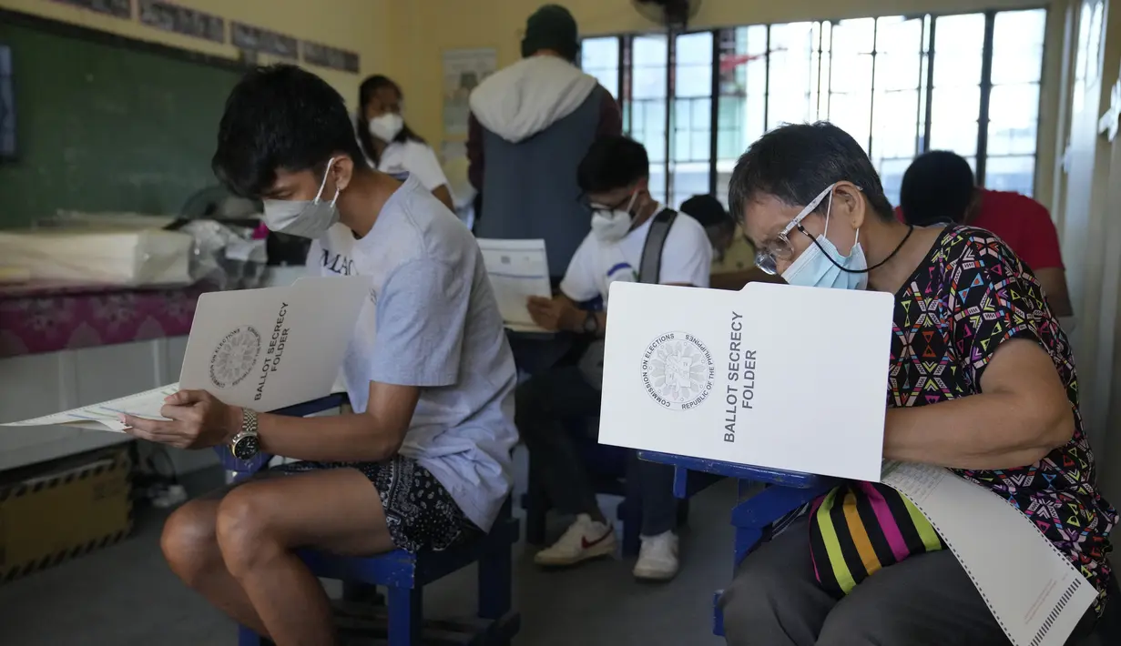 <p>Para pemilih memberikan suaranya pada Pemilu Filipina di Quezon City, Senin (9/5/2022). Warga Filipina mulai memberikan suara untuk memilih presiden baru pada hari Senin, dengan putra mantan diktator yang digulingkan menjadi pesaing terkuat seorang pejuang reformasi dan hak asasi manusia. (AP Photo/Aaron Favila)</p>