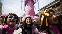 Orang-orang menggotong patung raksasa berbentuk penis pada perayaan Kanamara Matsuri di Kawasaki, 2 April 2017. (BEHROUZ MEHRI / AFP)