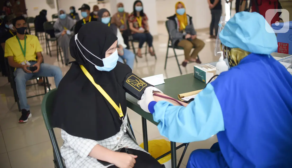 Tenaga kesehatan memeriksa tensi darah sebelum disuntik vaksin Coronavac di Rumah Sakit Darurat Covid-19 Wisma Atlet Kemayoran, Jakarta, Rabu (20/1/2021). Vaksinasi kepada 2.630 tenaga kesehatan menjadi prioritas karena bersinggungan langsung dengan pasien. (Liputan6.com/Fery Pradolo)