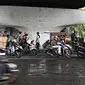 Pengendara sepeda motor berteduh di bawah flyover saat hujan turun, Jakarta, Senin (16/11). Memasuki musim hujan, polisi meminta pengendara untuk tidak berteduh di sembarang tempat, khususnya di bawah fly over. (Liputan6.com/Immanuel Antonius)