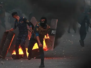 Pasukan keamanan berusaha membubarkan para demonstran saat protes antipemerintah di dekat Alun-Alun Tahrir, Baghdad, Irak, Senin (27/7/2020). Perdana Menteri Irak mengatakan telah memerintahkan penyelidikan atas pembunuhan dua demonstran antipemerintah. (AP Photo/Hadi Mizban)