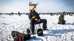 Tucker Welch memancing ikan dalam acara Brainerd Jaycees Ice Fishing Extravaganza tahunan ke-32 di Gull Lake's Hole di Teluk Day, Minnesota pada 29 Januari 2022. Hampir 10.000 pemancing dari Minnesota dan negara bagian lain menghadiri kontes memancing es amal terbesar di dunia. (Kerem Yucel/AFP)