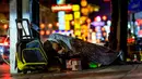 Seorang pria tunawisma tidur di jalan utama Chinatown Bangkok yang didekorasi untuk menyambut Tahun Baru Imlek (9/2/2021). Gubernur Asawin Kwanmuang mengumumkan bahwa pameran tahunan tidak akan dilaksanakan tahun Akibat pandemi COVID-19. (AFP/ Mladen Antonov)