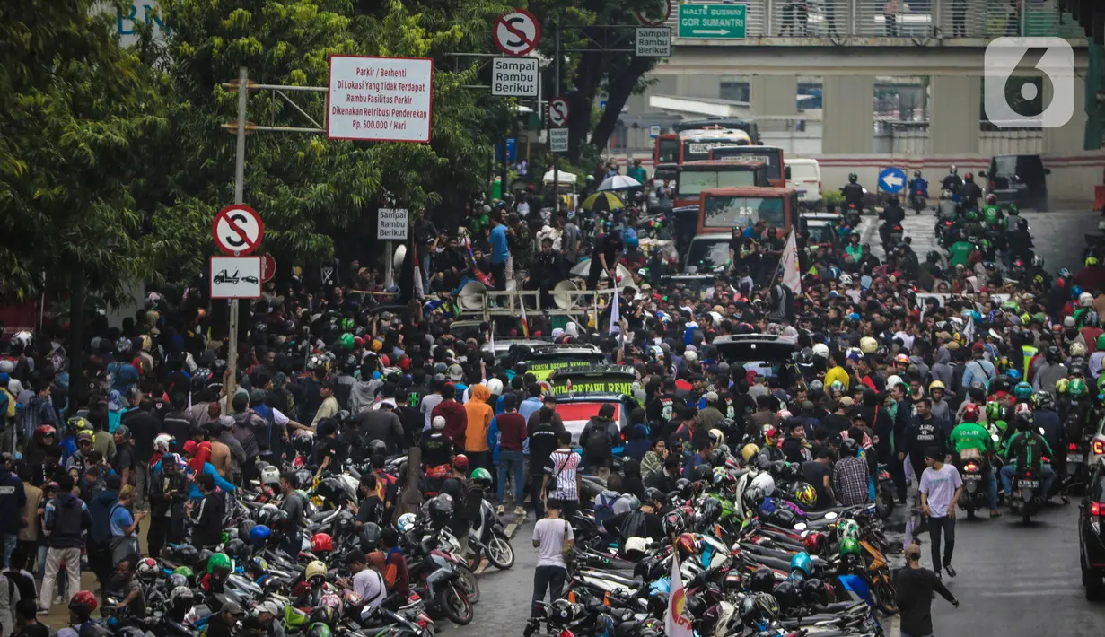 Kendaraan terpaksa berjalan tersendat di Jalan Rasuna Said, Kuningan, Jakarta, Rabu (22/1/2020). Kemacetan di depan Kantor Kemenkumham ini  imbas dari unjuk rasa warga Tanjung Priok yang memprotes dan menuntut Menkumham Yasonna Laoly minta maaf. (Liputan6.com/Faizal Fanani)