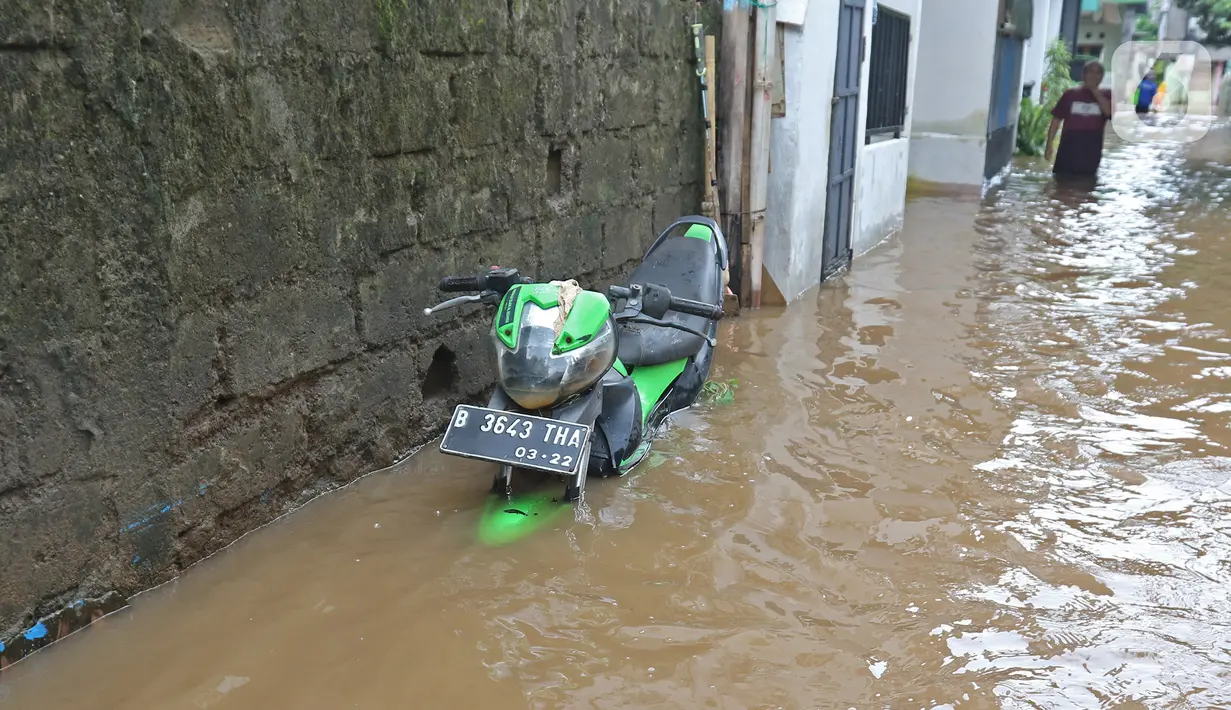 Sebuah motor terendam saat banjir melanda kawasan Cipinang Melayu, Jakarta Timur, Jumat (19/2/2021). Banjir di kawasan tersebut akibat curah hujan yang tinggi dan meluapnya air dari Kali Sunter. (Liputan6.com/Herman Zakharia)