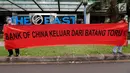 Aktivis WALHI bertopeng orangutan membentangkan spanduk tuntutan saat menggelar aksi di depan Gedung Bank of China, Jakarta, Jumat (1/3). Aksi ini digelar karena izin lingkungan PLTA Batang Toru dianggap cacat. (Liputan6.com/Fery Pradolo)