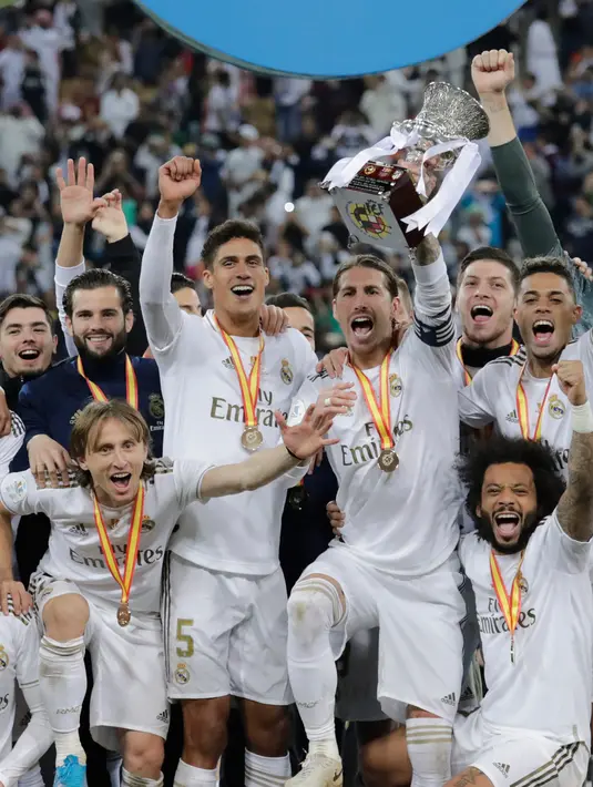 Pemain Real Madrid Sergio Ramos mengangkat trofi juara Piala Super Spanyol bersama rekan-reakannya usai mengalahkan Atletico Madrid pada pertandingan final di King Abdullah Stadium, Jeddah, Arab Saudi, Senin (13/1/2020). Real Madrid menang adu penalti 4-1. (AP Photo/Hassan Ammar)
