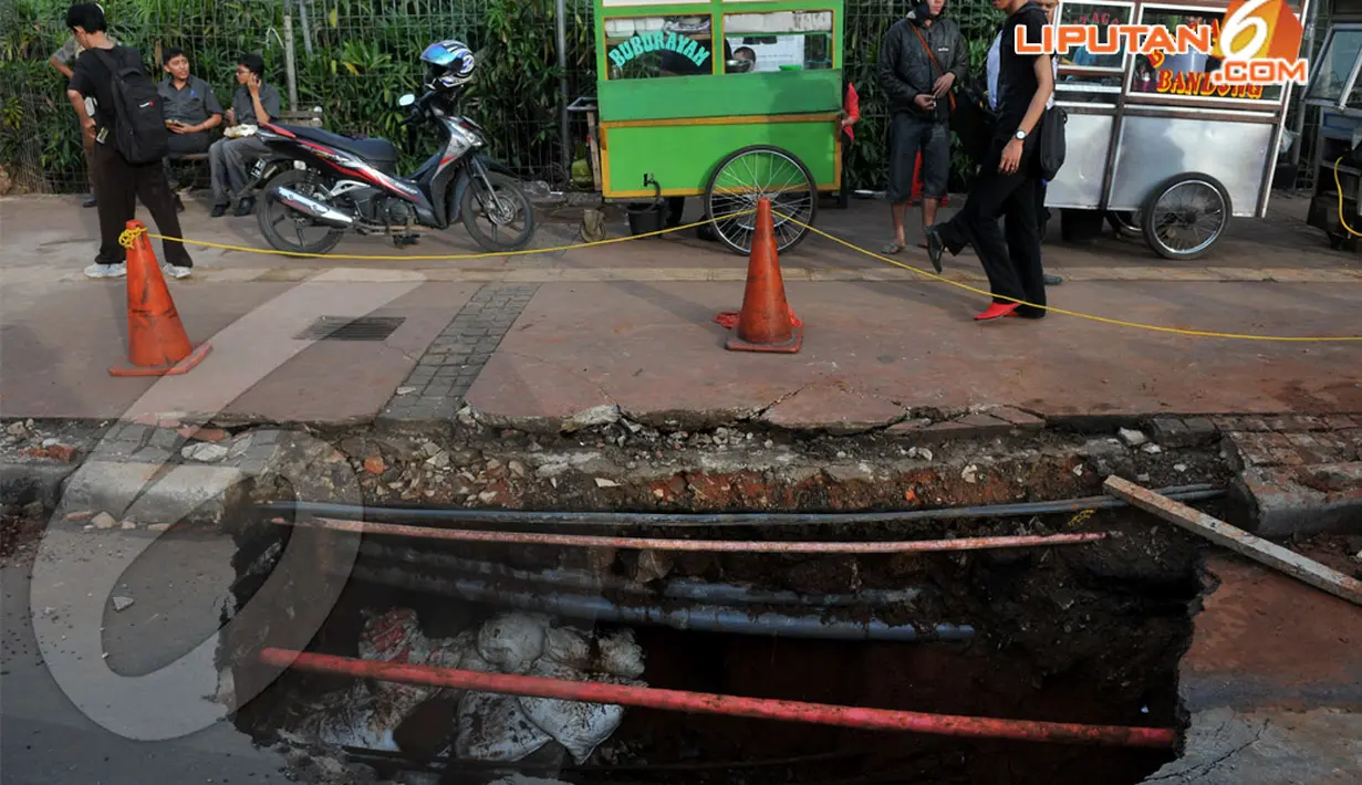 Amblasnya jalan diakibatkan oleh usia gorong-gorongnya sudah cukup lama. Ketika dinding tanah penahannya terkikis oleh air sehingga tak ada lagi penahan  . Kamis (10/4/2014)  (Liputan6.com/Johan Tallo).