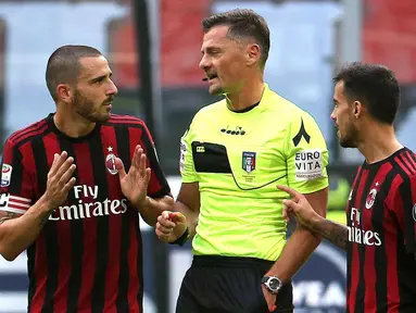 Bek AC Milan, Leonardo Bonucci (kiri) berbincang dengan wasit Piero Giacomelli setelah menerima kartu merah saat bertanding melawan Genoa pada lanjutan Liga Italia di San Siro, Milan (22/10). Bonucci di kartu merah menit 25. (Matteo Bazzi/ANSA via AP)