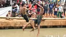 Anak-anak bermain lomba pukul bantal di sekitar Kalimalang, Jakarta, Sabtu (17/8/2019). Beragam lomba permainan digelar warga untuk menyemarakkan HUT ke-74 Republik Indonesia. (Liputan6.com/Helmi Fithriansyah)