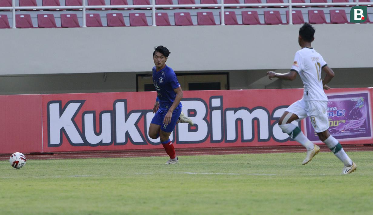 Bek Arema FC, Firza Andika (kiri) menguasai bola saat menghadapi Persikabo 1973 dalam laga pembuka Piala Menpora 2021 di Stadion Manahan, Solo, Minggu (21/3/2021). Arema FC bermain Imbang 1-1 dengan Persikabo 1973. (Bola.com/M Iqbal Ichsan)