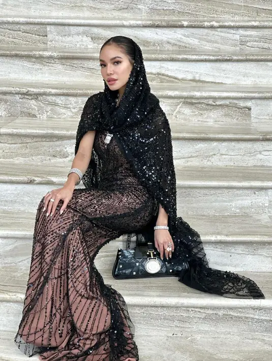 Gaun tersebut aslinya bergaya strapless. Agar tetap santun, Karraminah kemudian memadukannya dengan cape bertudung warna senada. [@_karraminah_]