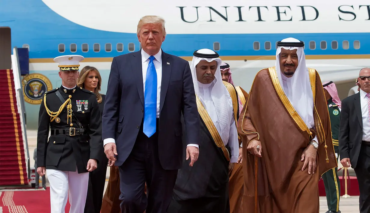 Donald Trump disambut Raja Salman saat tiba di Bandara Internasional Raja Khalid di Riyadh (20/5). Kunjungan ini akan membicarakan perjanjian politik dan perdagangan serta dukungan atas perang melawan para militan. (AFP/Saudi Royal Palace/Bandar Al-Jalou)