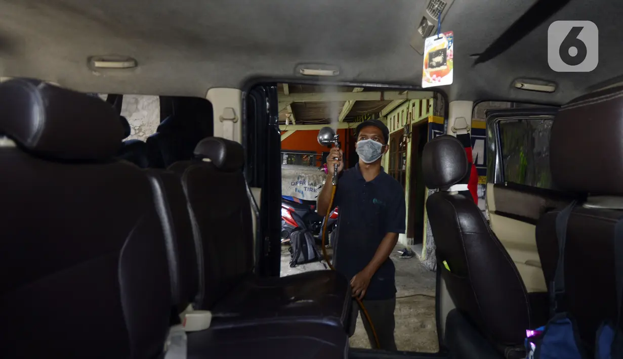 Pekerja menyemprotkan cairan disinfektan ke taksi online yang akan melakukan servis di Bengkel Yoyo, Pamulang, Tangerang Selatan, Banten, Rabu (2/4/2020). Penyemprotan disinfektan dilakukan untuk mengantisipasi  penyebaran virus corona COVID-19 antarpenumpang. (merdeka.com/Dwi Narwoko)