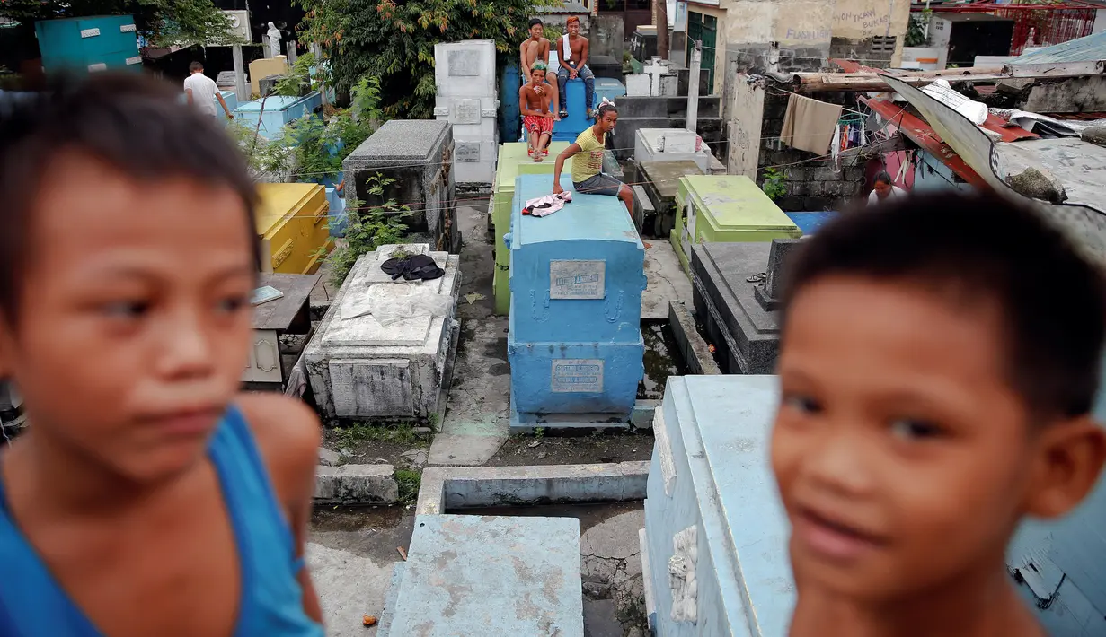 Anak-anak bermain di kuburan bergaya apartemen yang dibangun di North Cemetery, Manila, Minggu (16/10). Pemakaman ini menjadi lokasi penguburan korban tewas dalam perang melawan narkoba di Filipina. (Reuters/Damir Sagolj)