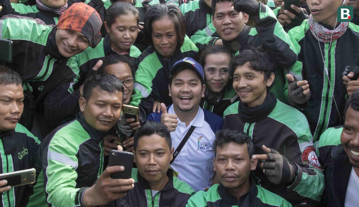 Aktor Indra Bekti foto bersama mitra Grab saat mengikuti pawai obor Asian Games XVIII di Lampung, Rabu (8/8/2018). Sebanyak 53 kota di Indonesia akan dilalui oleh obor Asian Games. (Bola.com/Reza Bachtiar)