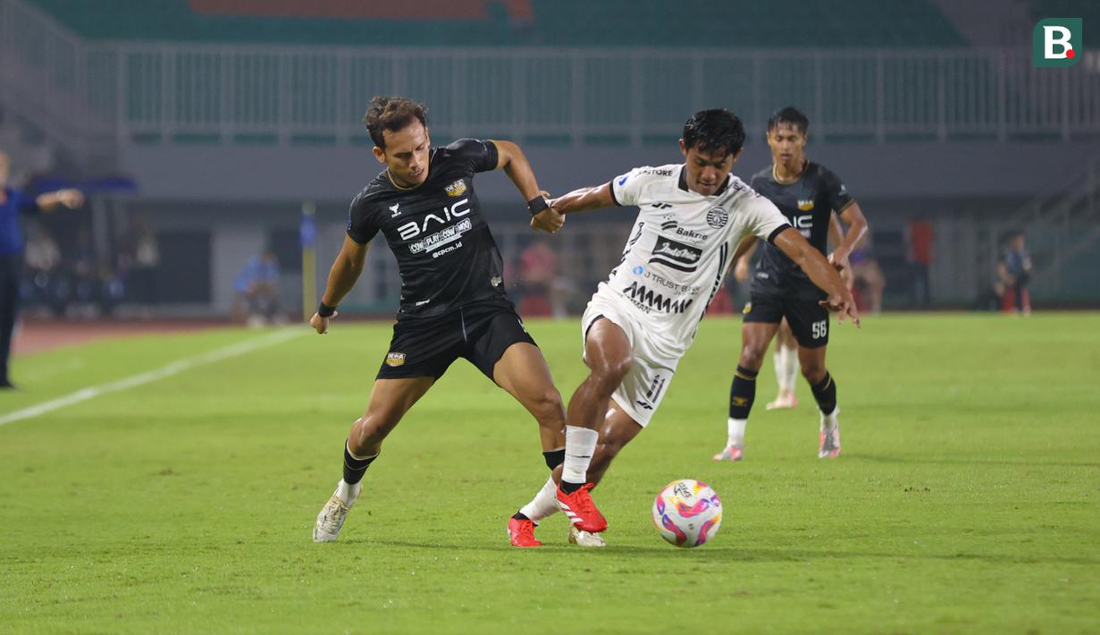 Egy Maulana Vikri berduel dengan Fizka Andika dalam laga pekan ke-22 BRI Liga 1 2024/2025 Dewa United vs Persija Jakarta di Stadion Pakansari, Sabtu (8/2/2025). (Bola.com/Abdul Aziz)