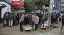 Orang-orang berkumpul dalam kelompok saat mereka menunggu hasil pemilihan di kota Eldoret, Kenya, Kamis, 11 Agustus 2022. Rakyat Kenya menunggu hasil pemilihan presiden yang berlangsung ketat namun tenang di mana jumlah pemilih lebih rendah daripada biasanya. (AP Photo/Brian Inganga)