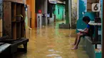 Seorang anak menikmati makanan saat banjir di kawasan Bidara Cina, Kecamatan Jatinegara, Jakarta Timur, Selasa (25/2/2020). Baru satu hari air surut, kawasan Bidara Cina yang bersebelahan dengan Kali Ciliwung kembali mengalami banjir. (merdeka.com/magang/ Muhammad Fayyadh)