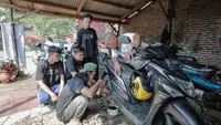 Sukarelawan Crivisaya Ganjar memberikan layanan oli secara gratis bagi masyarakat pengemudi sepeda motor. (Istimewa)