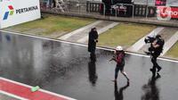 Pawang hujan yang diketahui bernama Mbak Rara berkeliling melakukan ritual untuk mencegah hujan terjadi dengan berbagai sesajen di Sirkuit Mandalika, Lombok, Nusa Tenggara Barat, Minggu (20/3/2022). Hujan membuat balapan MotoGP Mandalika ditunda. (Liputan6.com/Thomas)