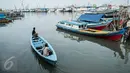 Warga menaiki perahu di Kampung Akuarium, Penjaringan, Jakarta Utara, Senin (30/1). Rencana tahap pertama revitalisasi  Kampung Akuarium adalah membuat tanggul setinggi 3,5 meter dari tepi laut. (Liputan6.com/Gempur M Surya)