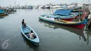 Warga menaiki perahu di Kampung Akuarium, Penjaringan, Jakarta Utara, Senin (30/1). Rencana tahap pertama revitalisasi  Kampung Akuarium adalah membuat tanggul setinggi 3,5 meter dari tepi laut. (Liputan6.com/Gempur M Surya)