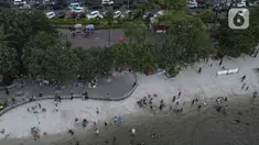Pemandangan udara warga berlibur di Pantai Ancol, Pademangan, Jakarta Utara, Rabu (1/6/2022). Libur Nasional Hari Lahir Pancasila, dimanfaatkan warga mengajak sanak saudara tamasya di Pantai Ancol. (Liputan6.com/Herman Zakharia)