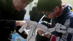 Seorang anak sedang mereparasi robotnya pada olimpiade sains di La Paz , Bolivia, Senin (10/8/2015). 150 robot dipamerkan disini dan dipilih siapa yang terbaik. (REUTERS/David Mercado)